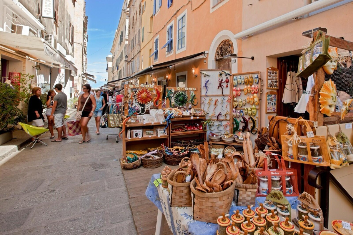 Ruelle de marché avec étals de produits et artisanat corses à Porto-Vecchio